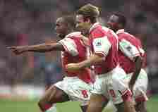 Ian Wright of Arsenal (centre) leads the celebrations with a little help from teammates Paul Merson (foreground) and Patrick Vieira (background)  d...