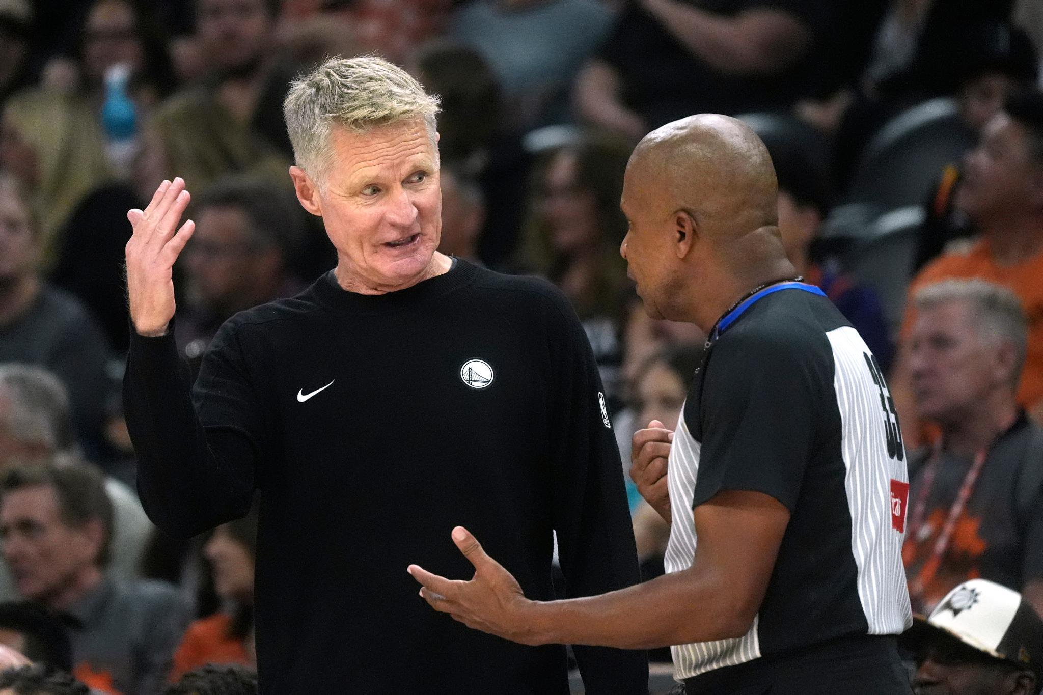 Steve Kerr speaking with referee Sean Corbin on the court.