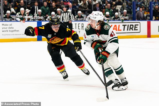 Minnesota Wild's Quinn Hughes (43) skates past Vancouver Canucks' Brendan Gallagher (7) during the second period of an NHL hockey game, in Vancouver, British Columbia, Sunday, Oct. 25, 2026. (Jacob Mallari/The Canadian Press via AP)