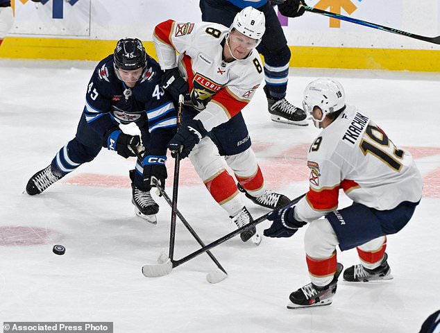 Winnipeg Jets' Cole Koepke (45) battles for the puck against Florida Panthers' Brady Tkachuk (8) and Matthew Tkachuk (19) during third period NHL action in Winnipeg on Tuesday, Oct. 27, 2026. (Fred Greenslade/The Canadian Press via AP)