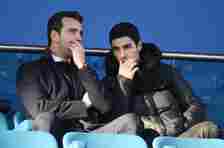 Mikel Arteta and Edu sitting in the stands having a conversation