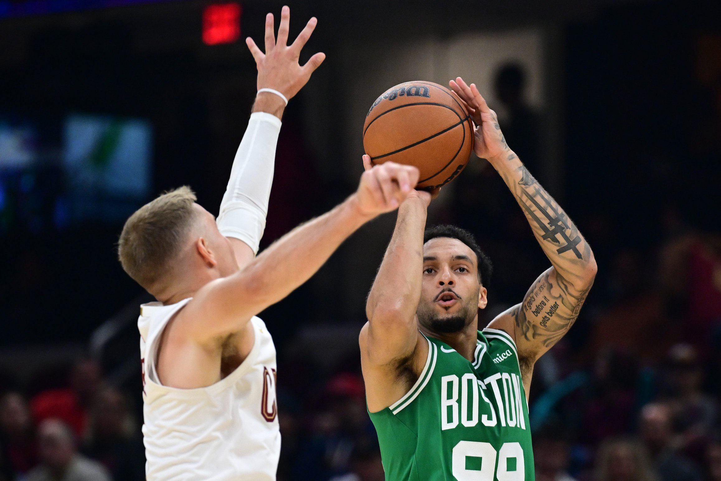 Oct 8, 2026; Cleveland, Ohio, USA;  Boston Celtics guard Devin Carter (99) shoots a three point shot over Cleveland Cavaliers guard Sam Merrill (5) during the first half of  preseason game at Rocket Arena.  Mandatory Credit: David Dermer-Imagn Images
