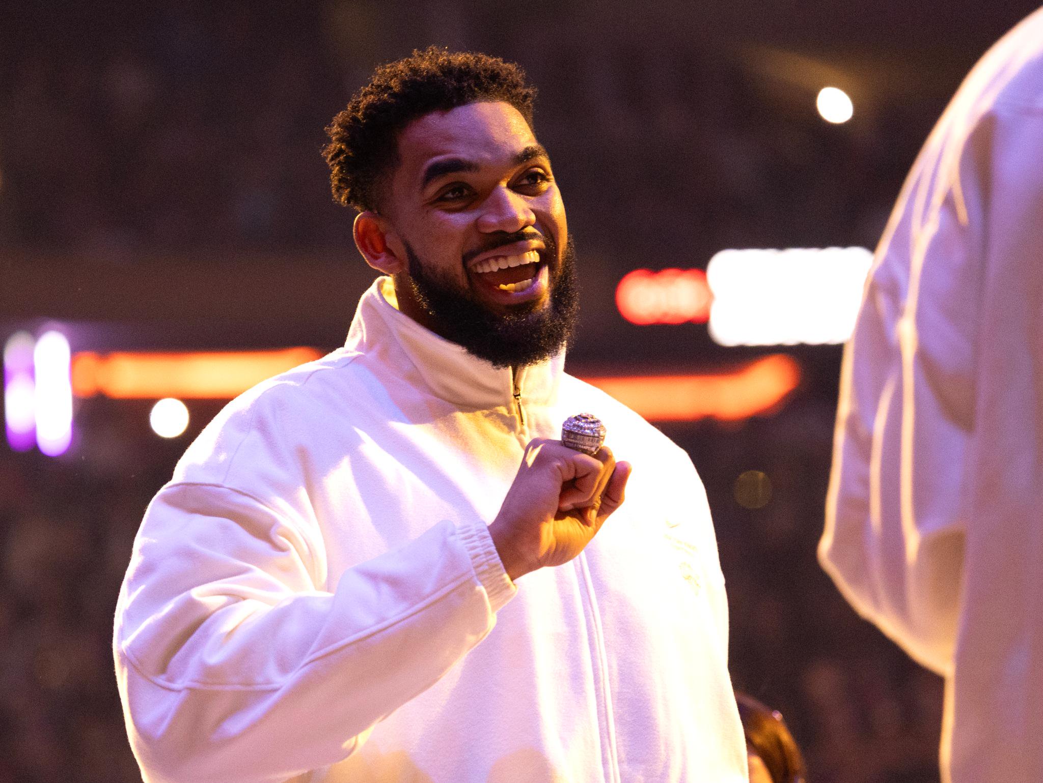 New York Knicks center Karl-Anthony Towns smiles after receiving his championship ring before a game.