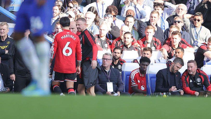 Manchester United coach Jonny Evans speaks to Lisandro Martinez following his red card at Stamford Bridge