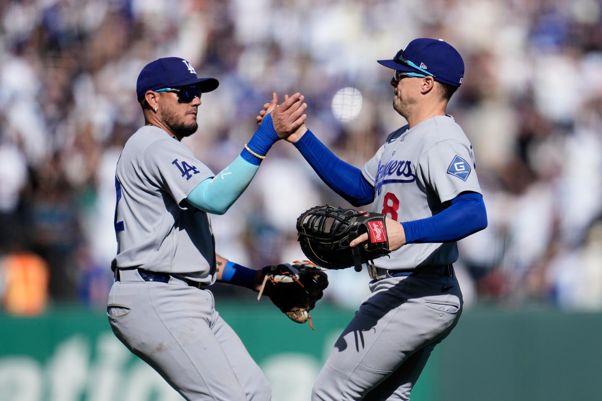 Los Angeles Dodgers players Miguel Rojas and Enrique Hernández celebrate after a game.