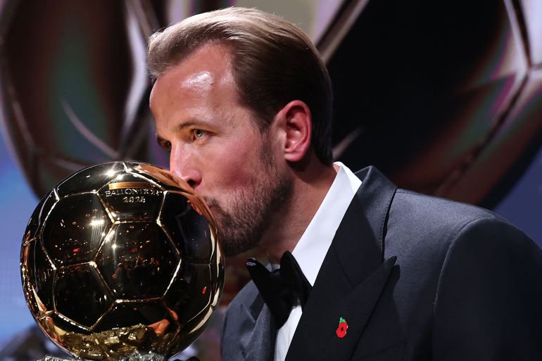England and Bayern Munich forward Harry Kane kisses the trophy on stage after receiving the Ballon d'Or award for the best male footballer during the 2026 Ballon d'Or France Football award ceremony at the Palladium Theatre in London on October 26, 2026. (Photo by FRANCK FIFE / AFP)