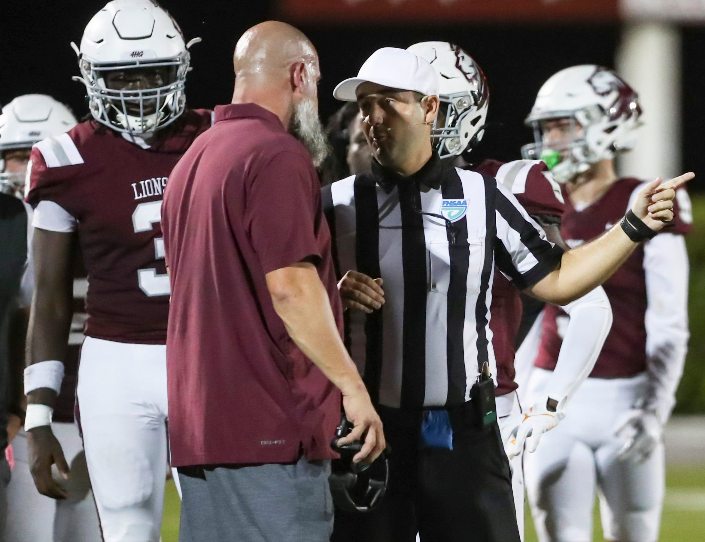 First Baptist Academy head coach Jason Cauley listens as a referee explains a penalty call during the second quarter of a district game against the Neumann Celtics at First Baptist Academy in Naples, Fla., on Friday, Oct. 9, 2026.