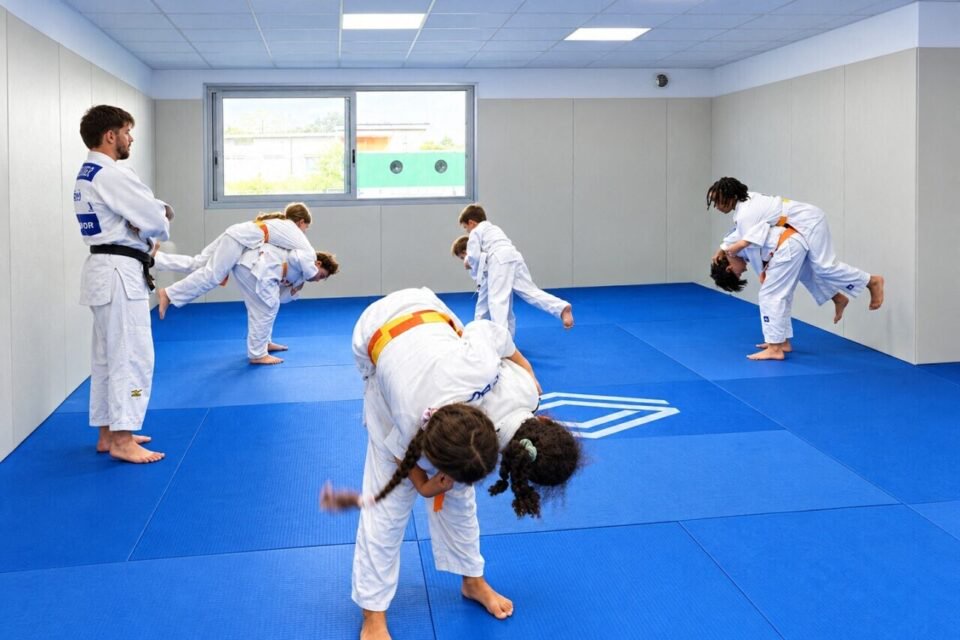 Le professeur Ewen Le Flohic étudiant en STAPS et possédant un certificat de qualification professionnelle Judo avec ses élèves et les petits judokas en action