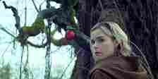 Sabrina looks back in front of a hanging apple in Chilling Adventures of Sabrina.