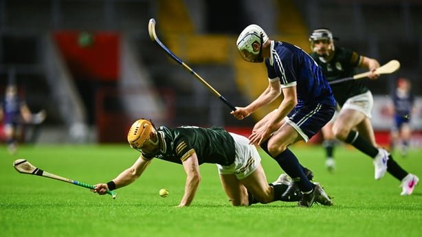 Andrew Ormond of Ireland in action against Rory Kennedy of Scotland during the 2026 Hurling/Shinty International match between Ireland and Scotland at SuperValu Páirc Uí Chaoimh in Cork