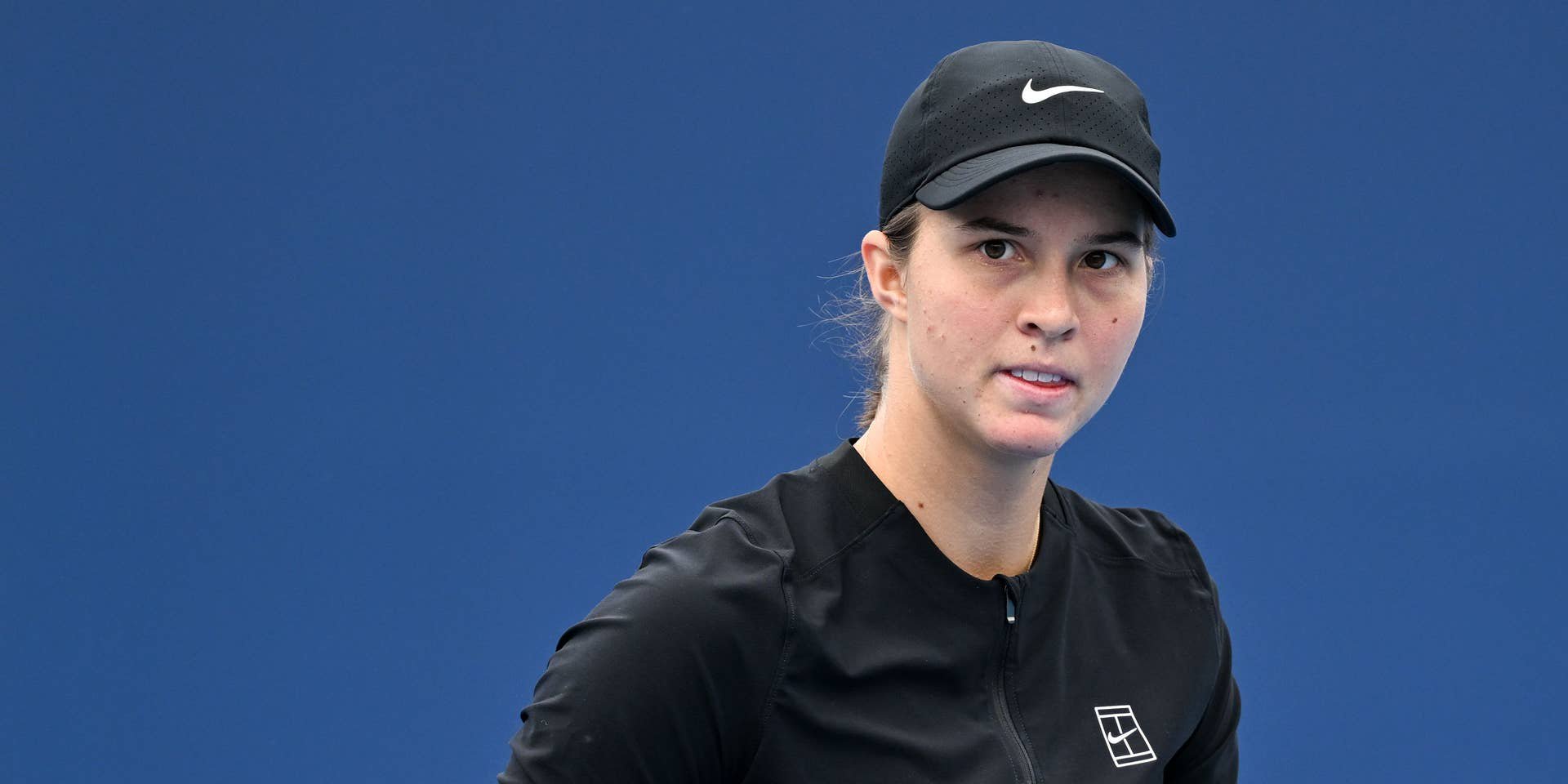 Eine Tennisspielerin in schwarzer Kleidung ballt die Faust auf dem Platz.