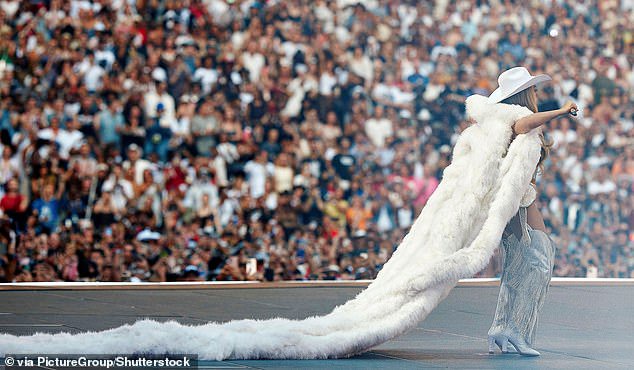 With a stadium full of her cheering fans, Beyonce took to the stage in a glamorous outfit with a fur vest with an incredibly long train trailing behind her as she strutted around onstage