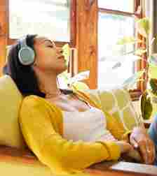 Woman relaxes with headphones on, she is sensitive