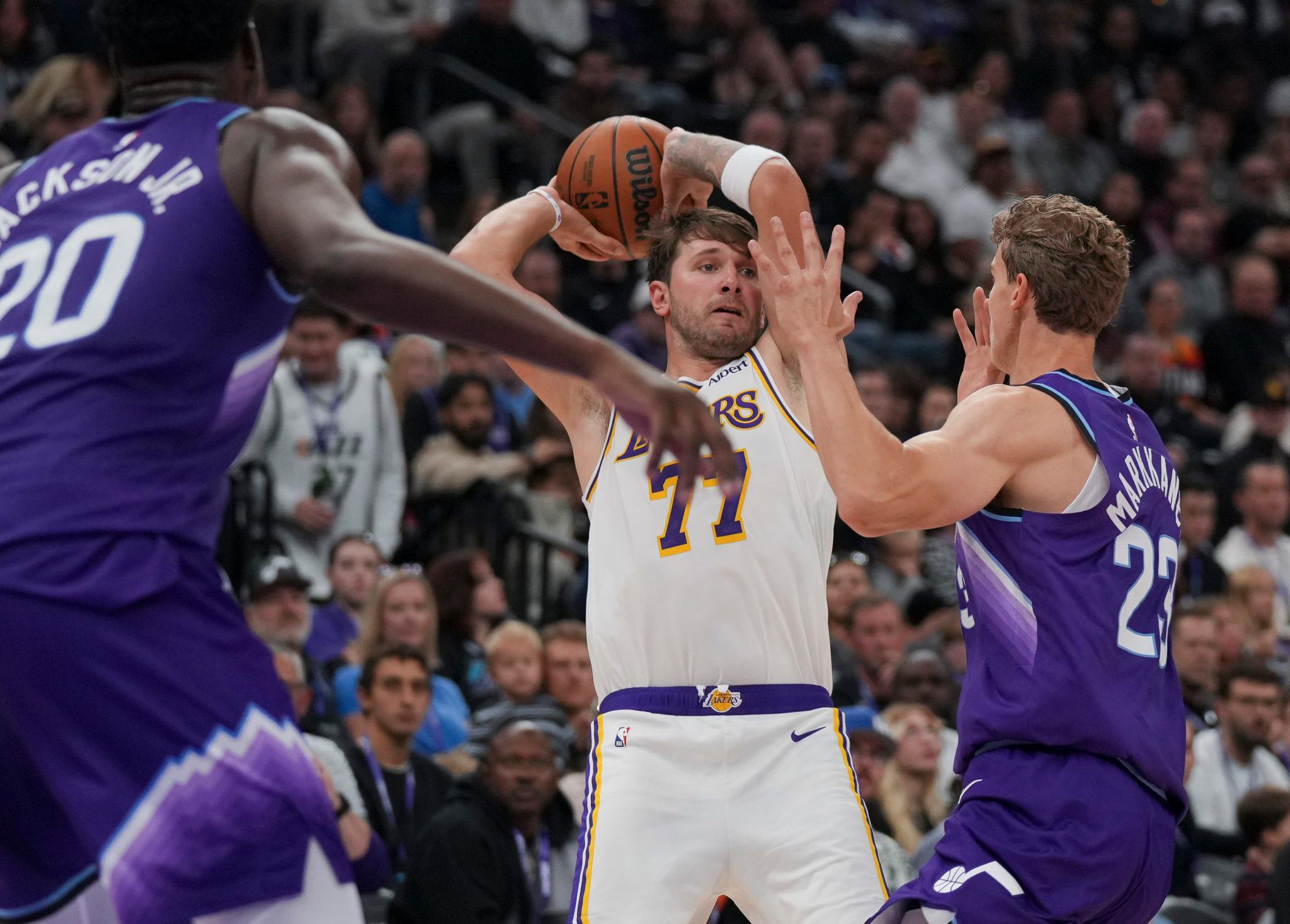 Los Angeles Lakers forward/guard Luka Dončić (77) looks to pass the ball as Utah Jazz forward/center Lauri Markkanen (23) blocks during a basketball game.