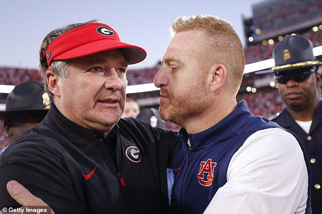 Head coach Kirby Smart of the Georgia Bulldogs speaks with Head coach Alex Golesh of the Auburn Tigers following the 27-24 victory over the Georgia Bulldogs at Sanford Stadium