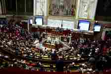 A general view shows the hemicycle as members of parliament react after the vote on a motion to dismiss the text before a debate on immigration law at the French National Assembly in Paris, France, De