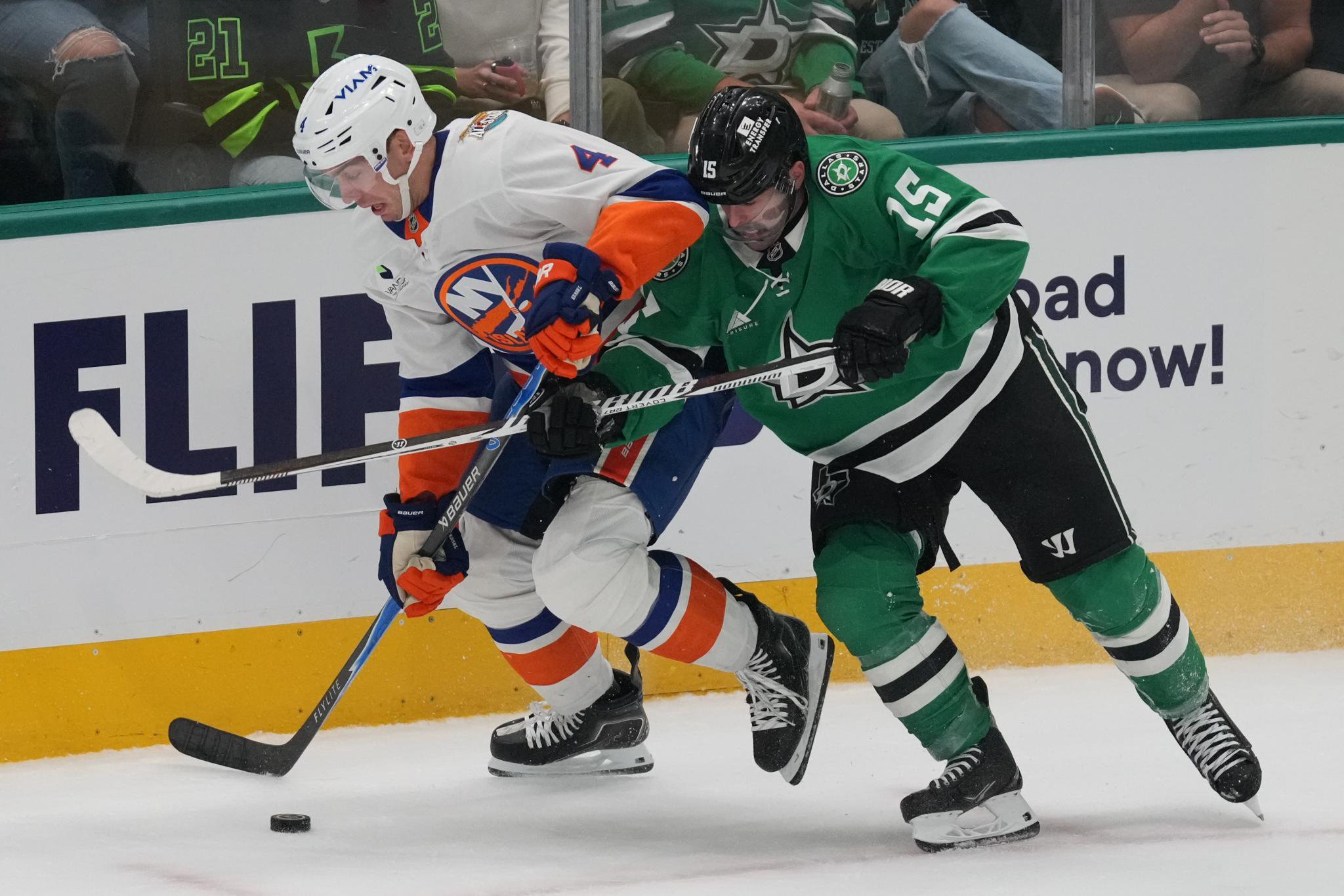 New York Islanders defenseman Matthew Kessel controls the puck in front of Dallas Stars center Colin Blackwell during an NHL hockey game.