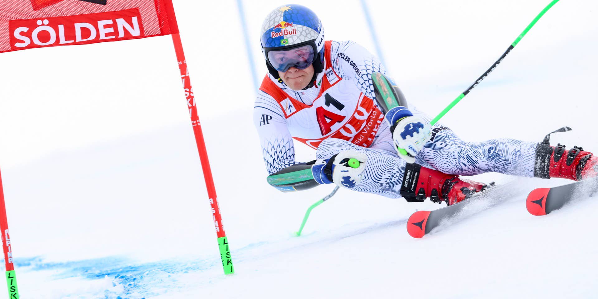 Ein Skirennläufer fährt beim Riesenslalom durch ein Tor auf schneebedeckter Piste in Sölden.