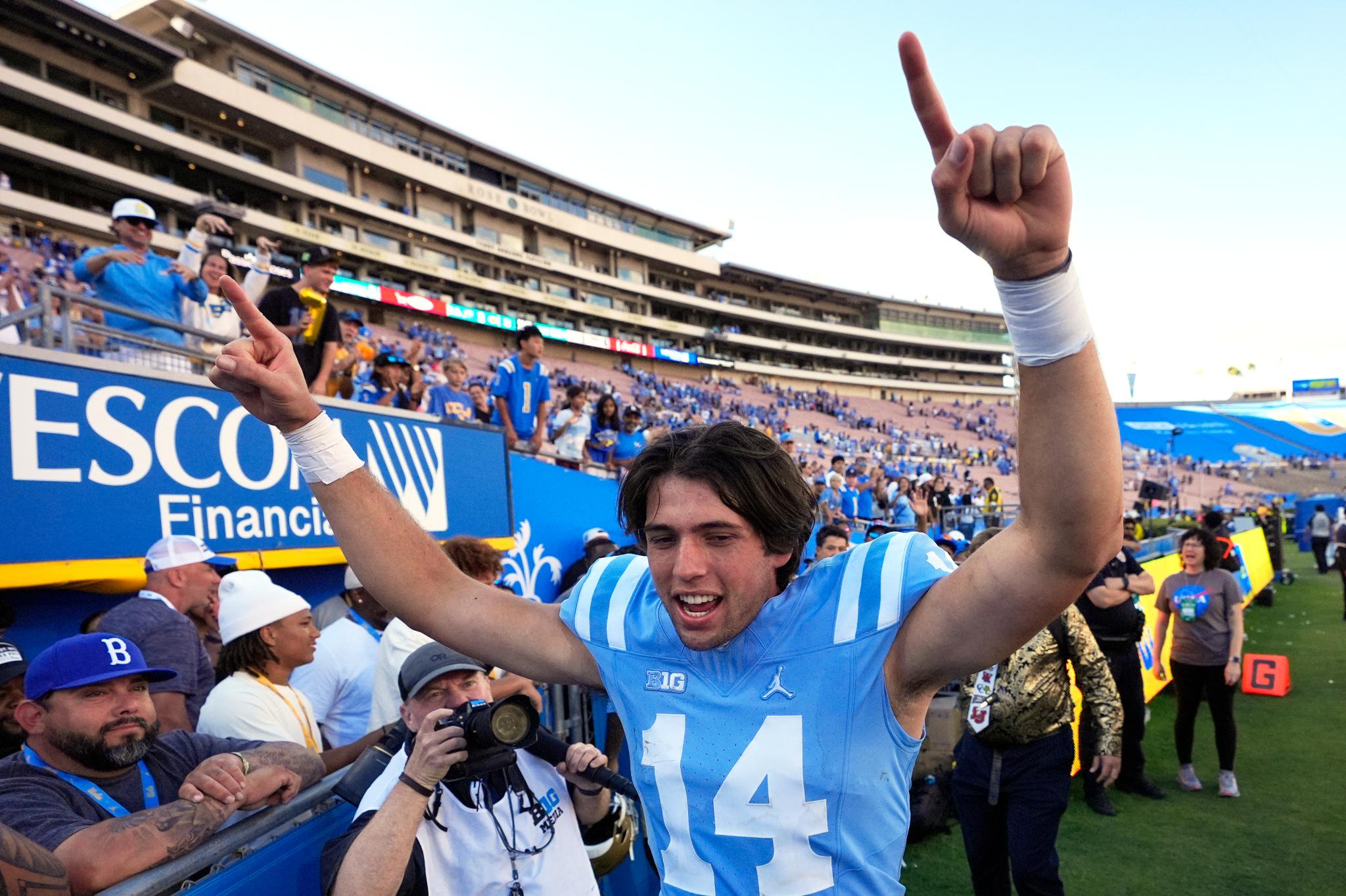 Ty Dieffenbach celebrating on the field with arms raised.