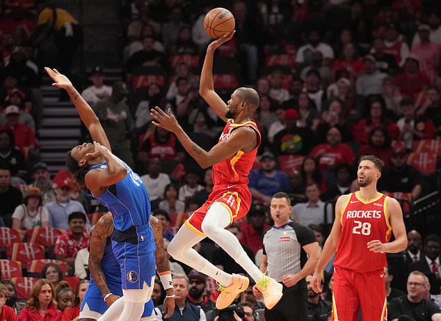 Houston Rockets forward Kevin Durant, center, shoots the ball over Dallas Mavericks forward Morez Johnson Jr., left, during the first half of an NBA basketball game, Wednesday, Oct. 21, 2026, in Houston. (AP Photo/Karen Warren)