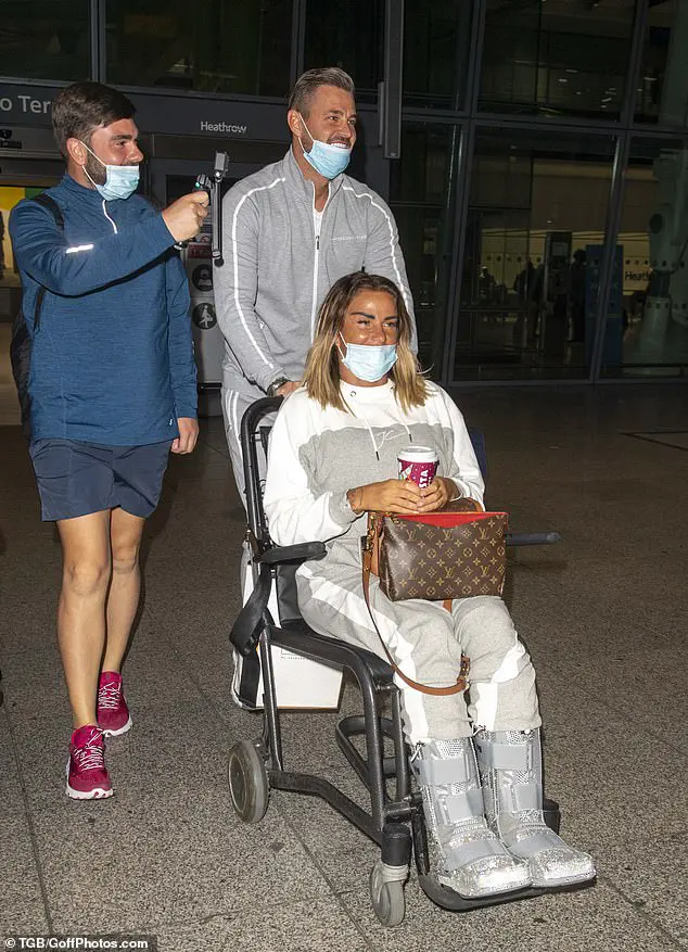 Happy: Katie and Carl giggled as he wheeled her to their car, while she sporting glittering casts on both feet