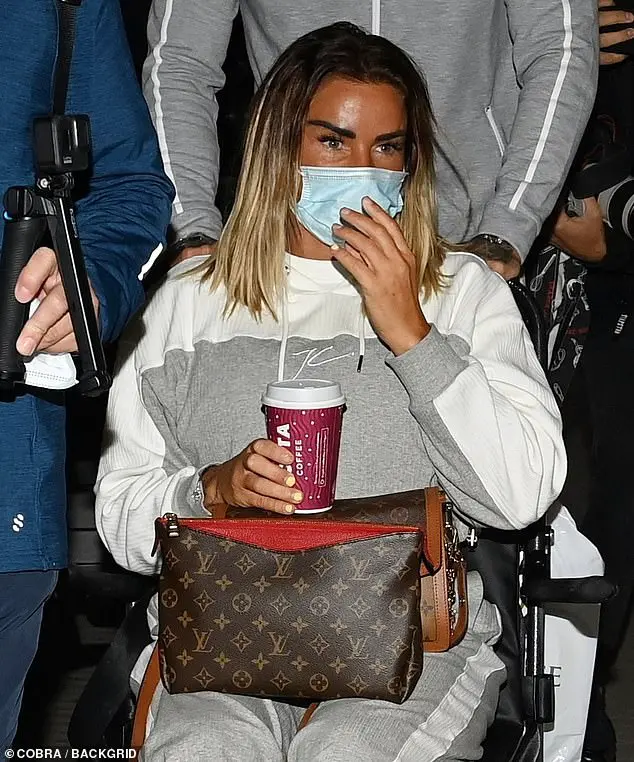 Back to reality: Katie Price got a helping hand from boyfriend Carl Woods as they returned home from the Maldives on Thursday in matching tracksuits