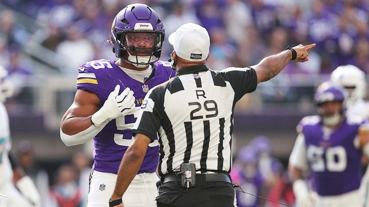 Eric Wilson talks with referee Adrian Hill during an NFL game.