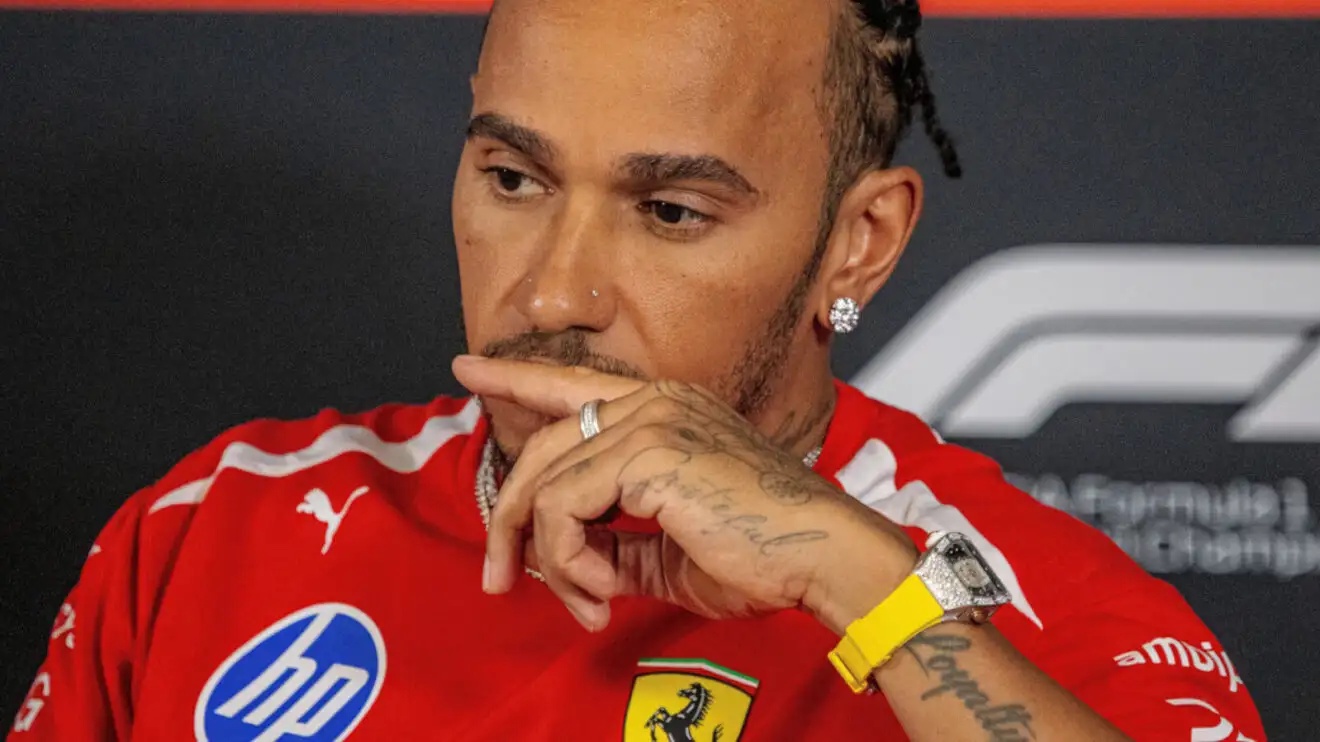 Lewis Hamilton in a press conference with his hand in front of his mouth