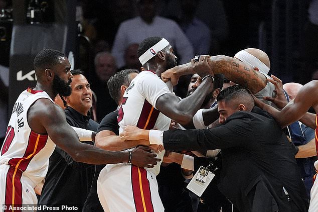 People try to separate Miami Heat forward Bobby Portis Jr., center, and Dallas Mavericks forward Daniel Gafford, right, during an altercation in the first half of an NBA basketball game, Monday, Oct. 26, 2026, in Miami. (AP Photo/Rebecca Blackwell)
