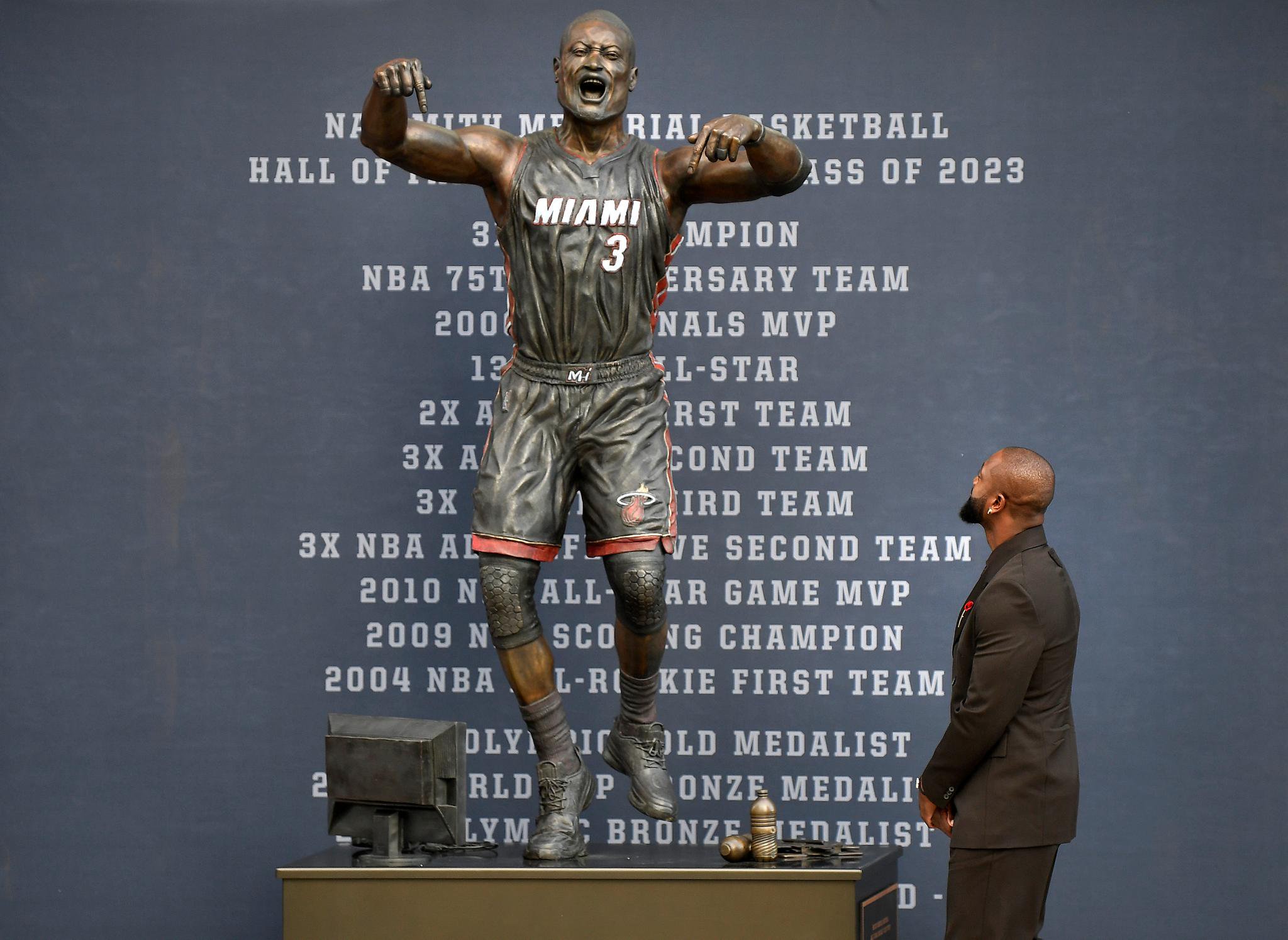 Former Miami Heat NBA basketball player Dwyane Wade looks at a bronze statue of himself outside Kaseya Center in Miami, Fla., Sunday, October 27, 2024.