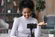 Smiling African American woman record video on cellphone