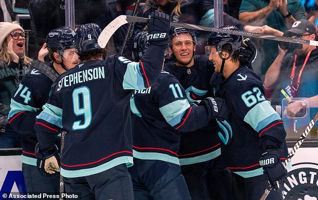 From left, Seattle Kraken, forward Bobby McMann, forward Chandler Stephenson, forward Mackie Samoskevich, defenseman Ryker Evans and defenseman Brandon Montour celebrate a goal during the third period of an NHL hockey game, Thursday, Oct. 22, 2026, in Seattle. (AP Photo/Stephen Brashear)