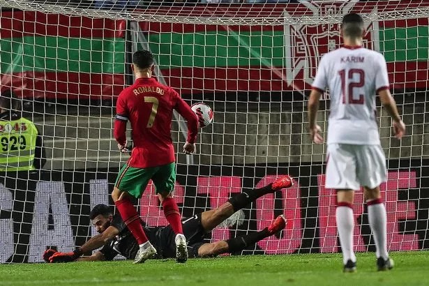 Portugal's forward Cristiano Ronaldo (C) scores a goal during the international friendly football match between Portugal and Qatar at the Algarve stadium in Loule, near Faro, southern Portugal, on October 9, 2021.