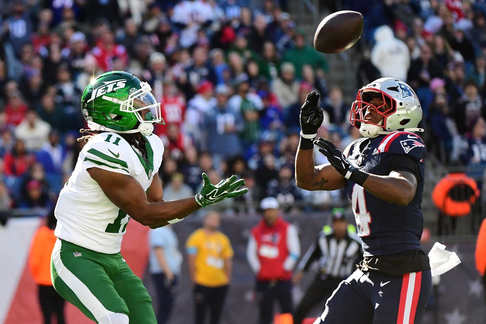 Oct 18, 2026; Foxborough, Massachusetts, USA;  New York Jets wide receiver Omar Cooper Jr. (11) catches the ball past New England Patriots safety Craig Woodson (4) for a touchdown during the second half at Gillette Stadium. Mandatory Credit: Bob DeChiara-Imagn Images