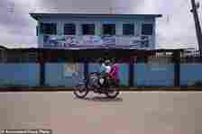 A motorcycle taxi rides past Lorat Nursery and Primary School in Ibadan, Nigeria, Tuesday, May 28, 2024. The lack of reliable electricity severely affects education and businesses in Nigeria. (AP Photo/Sunday Alamba)