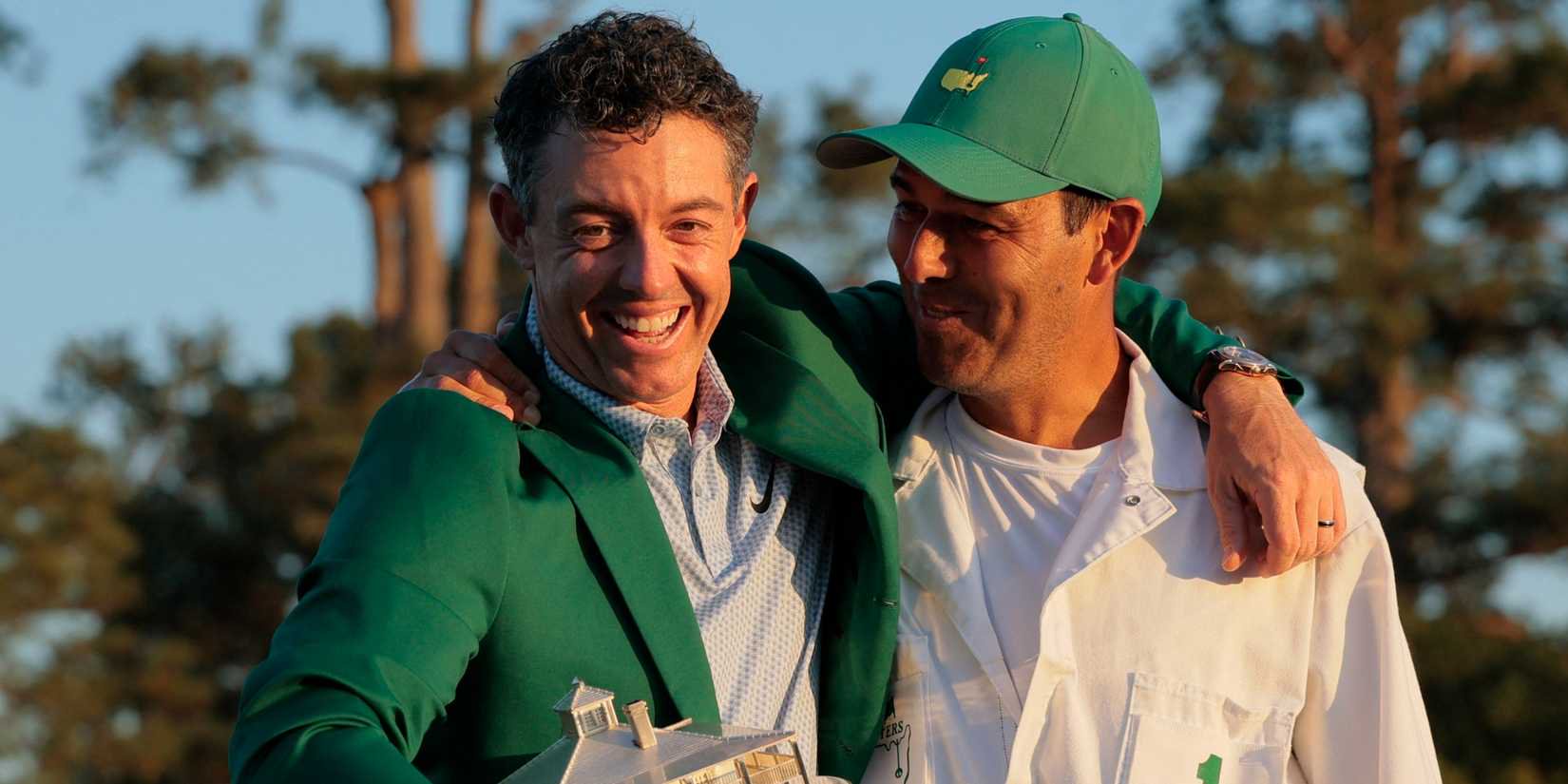 Rory McIlroy celebrates with his caddy after winning the Masters