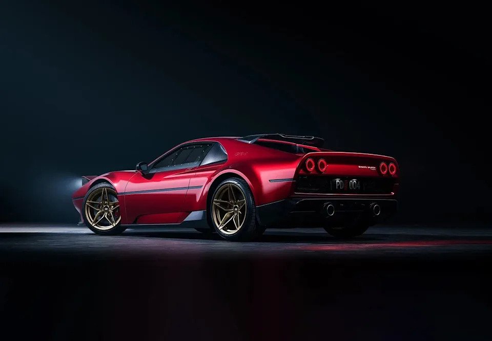 A sleek red sports car with a modern design and gold wheels, set against a dark background.