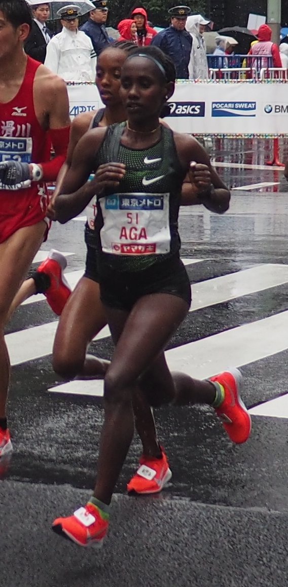 Ruti Aga, wearing bib number 51, runs in the 2019 Tokyo Marathon with spectators behind her
