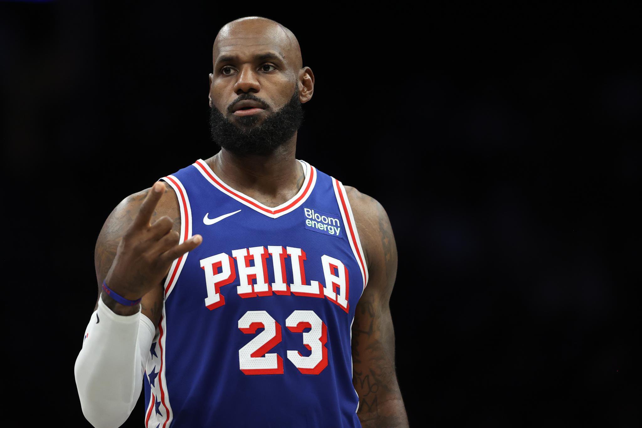 LeBron James gestures to teammates while wearing a Philadelphia 76ers jersey during an NBA game.