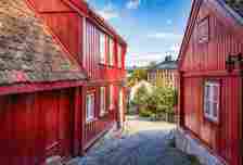 A sloping cobbled street between two red wooden houses stretches throughout the village.