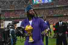 Former Togolese football star Emmanuel Adebayor carries the Africa Cup of Nations trophy to the podium after Ivory Coast won the Africa Cup of Nati...