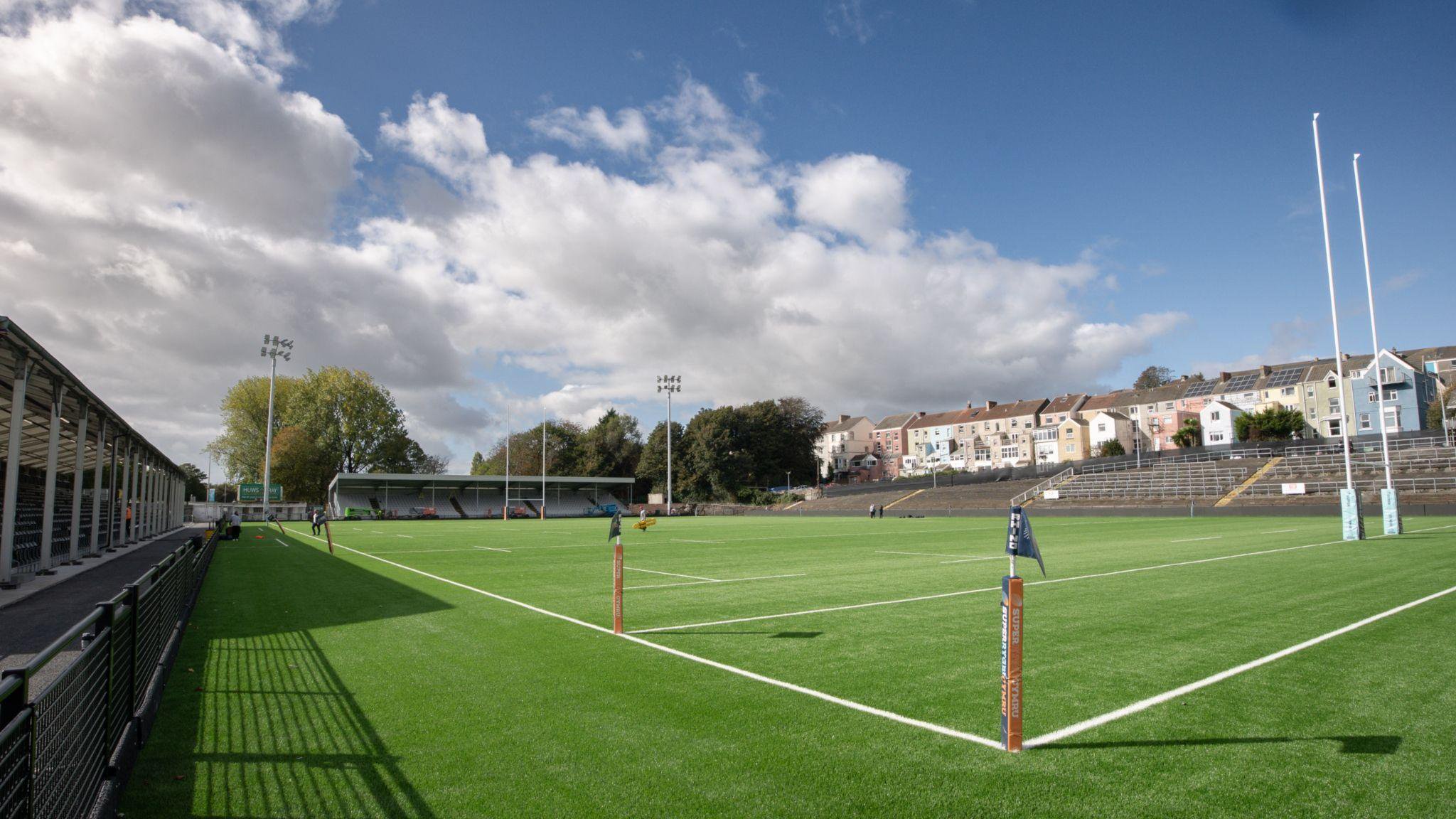 Wide view of St Helen's across the pitch from one corner with stands to the left and the far side and terracing in front of houses to the right