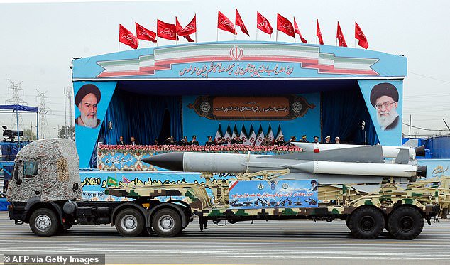 An Iranian military truck carrying a missile drives in front of the officials' stand during a military parade in 2019