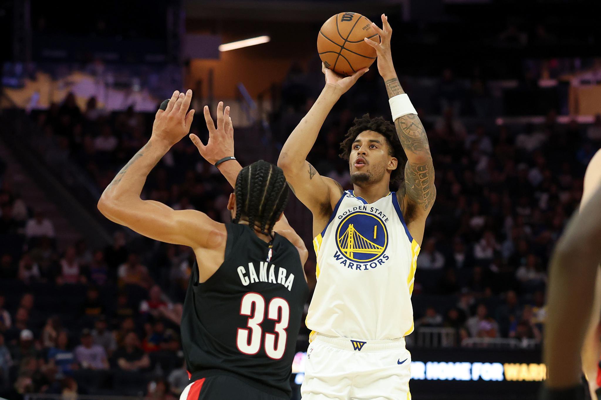 Golden State Warriors' Yaxel Lendeborg shoots over Portland Trail Blazers' Toumani Camara during a game.