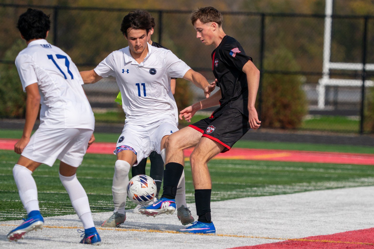 Lincoln-Way Central's Nathan Claybrook, right, plays the ball as Lincoln-Way East's Owen Bohren (11) and Santiago Espinosa (17) defend a Class 3A regional final in New Lenox on Saturday, Oct. 24, 2026. (Sean King / Southtown)