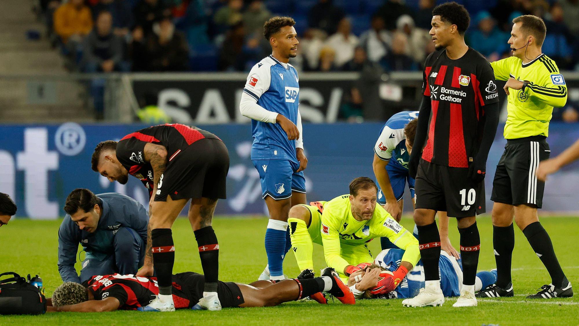 v.l.n.r.: LoÃc BadÃ , Loic Bade Bayer 04 Leverkusen und Max Moerstedt TSG Hoffenheim knallen mit den Köpfen zusammen und bleiben liegen, im Bundesliga-Spiel zwischen der TSG 1899 Hoffenheim und Bayer 04 Leverkusen in der PreZero Arena, Sinsheim, Deutschland, am 25. Oktober 2026. in action during the Bundesliga match between TSG 1899 Hoffenheim and Bayer 04 Leverkusen at the PreZero Arena, Sinsheim, Germany, on October 25, 2026. DFB/DFL REGULATIONS PROHIBIT ANY USE OF PHOTOGRAPHS AS IMAGE SEQUENCES AND/OR QUASI-VIDEO, *** From left to right: Loïc Bade of Bayer 04 Leverkusen and Max Moerstedt of TSG Hoffenheim collide heads and remain on the ground during the Bundesliga match between TSG 1899 Hoffenheim and Bayer 04 Leverkusen at the PreZero Arena, Sinsheim, Germany, on October 25, 2026, in action during the Bundesliga match between TSG 1899 Hoffenheim and Bayer 04 Leverkusen at the PreZero Arena, Sinsheim, Germany, on October 25, 2026. DFB and DFL regulations prohibit any use of photographs as image sequences and/or quasi-video, Copyright: HMBxMedia/xHeikoxBecker
