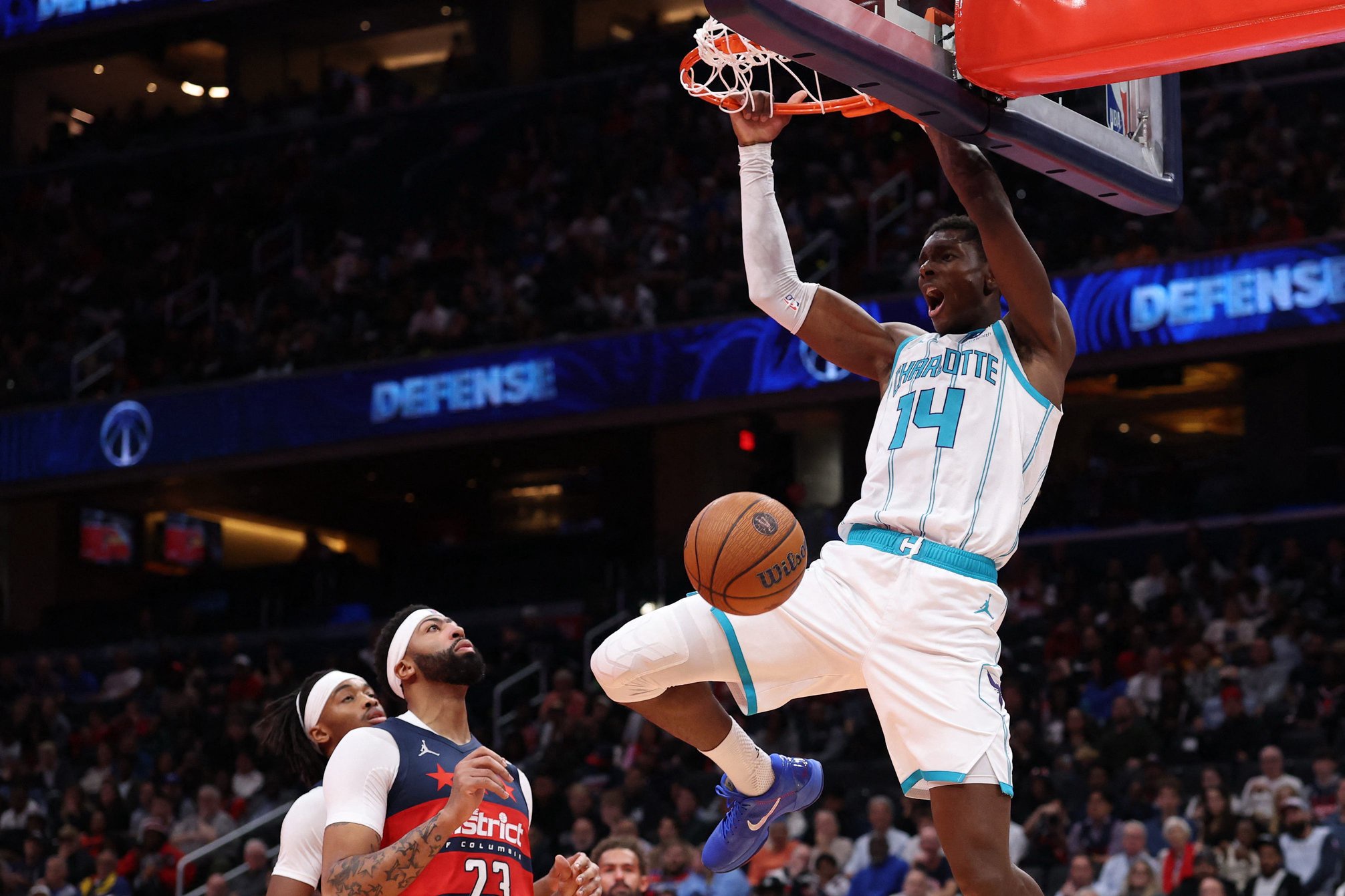 Oct 30, 2026; Washington, District of Columbia, USA; Charlotte Hornets forward Moussa Diabate (14) dunks the ball as Washington Wizards forward Anthony Davis (23) looks on in the first half in an NBA Cup game at Capital One Arena. Mandatory Credit: Geoff Burke-Imagn Images