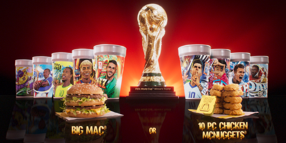 World Cup trophy surrounded by player-themed cups, Big Mac, and Chicken McNuggets against a red background.