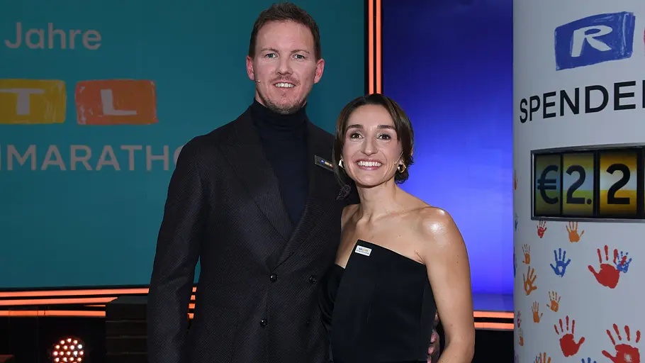 Julian Nagelsmann und Lena Wurzenberger stehen nebeneinander auf einer Bühne und lächeln in die Kamera. Im Hintergrund ist eine Veranstaltungskulisse mit „RTL Spendenmarathon“ zu sehen.