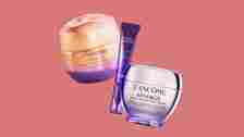 3 cosmetic items overlapping on a pink background. From left to right Gold and purple rounded jar squeezable purple tube...